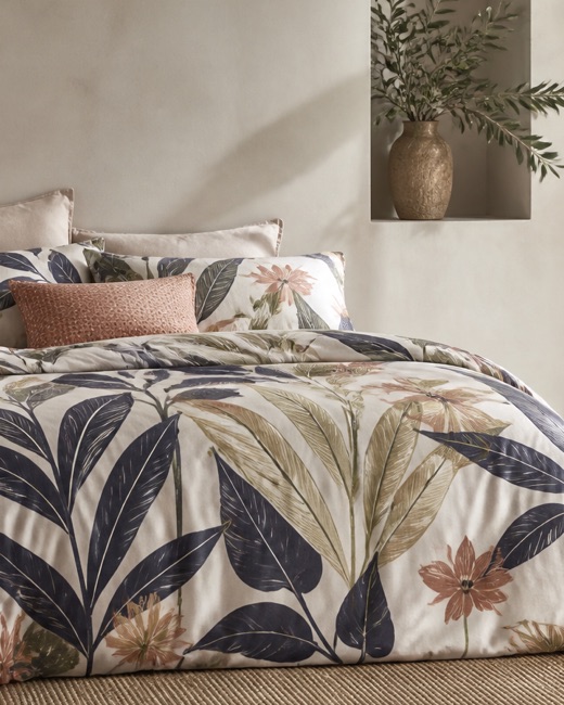 Large-scale painted botanical print across a duvet cover and pillowcases.