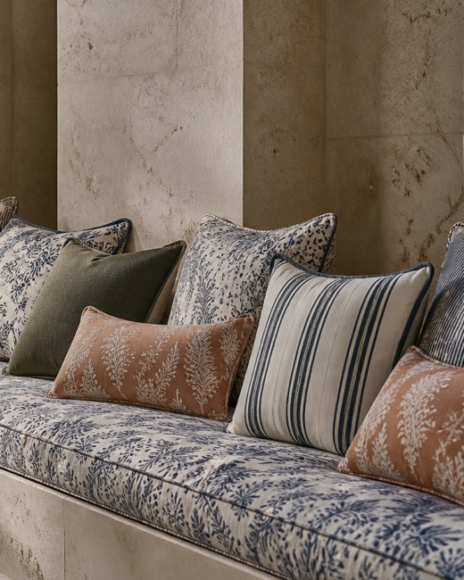 Piped outdoor cushions in indigo botanicals, stripes and terracotta prints.