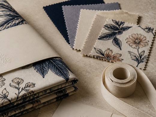 Fabric swatches, printed samples and cotton ribbon arranged for a private-label collection.